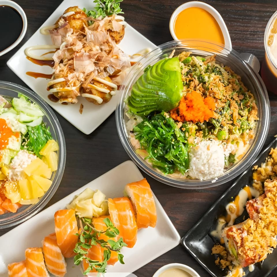 Overhead view of various Poki Yaki dishes, including poke bowls, sushi, and takoyaki.